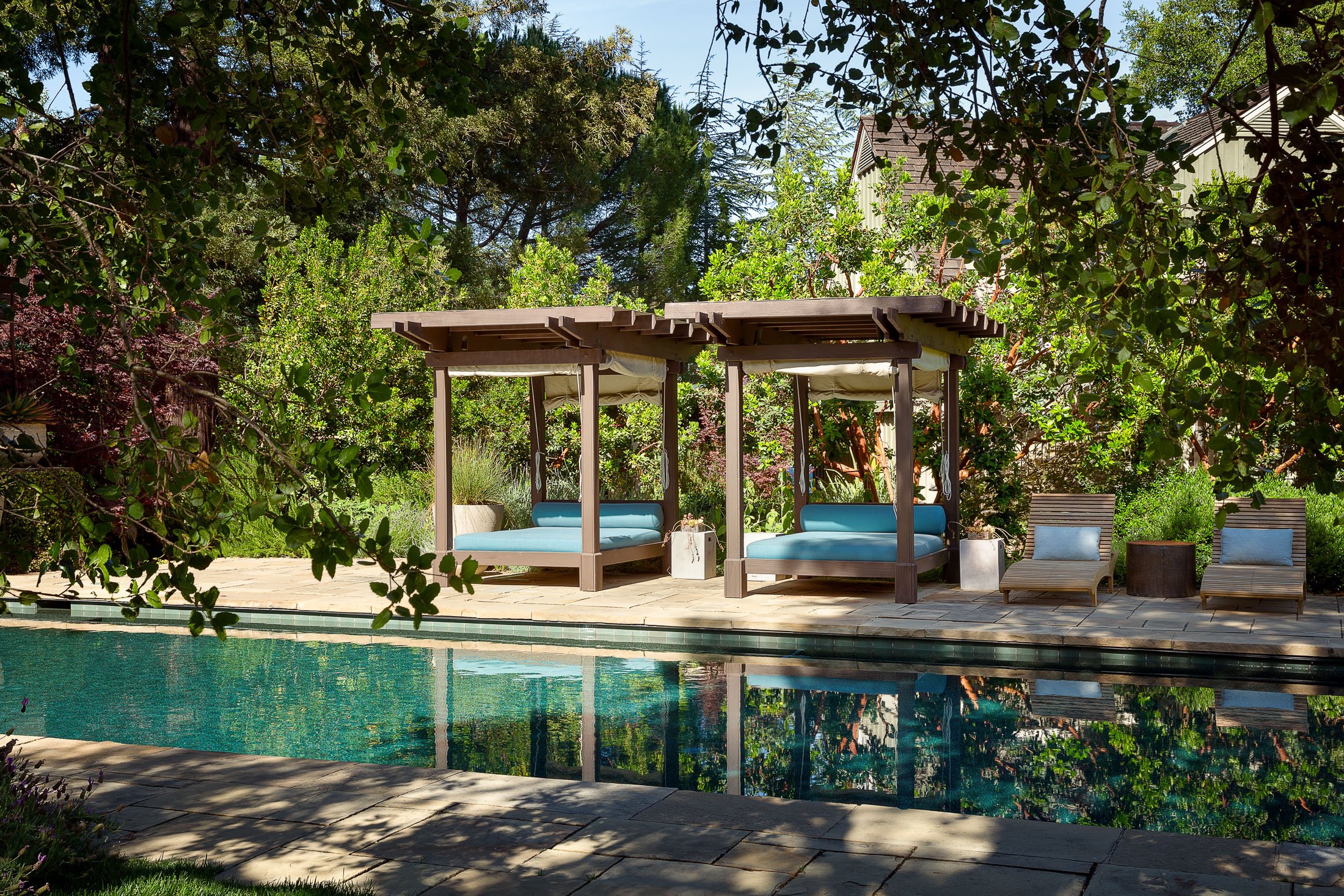 Outdoor Lounge Area with Poolside Cabanas and Lush Greenery in Woodside, CA