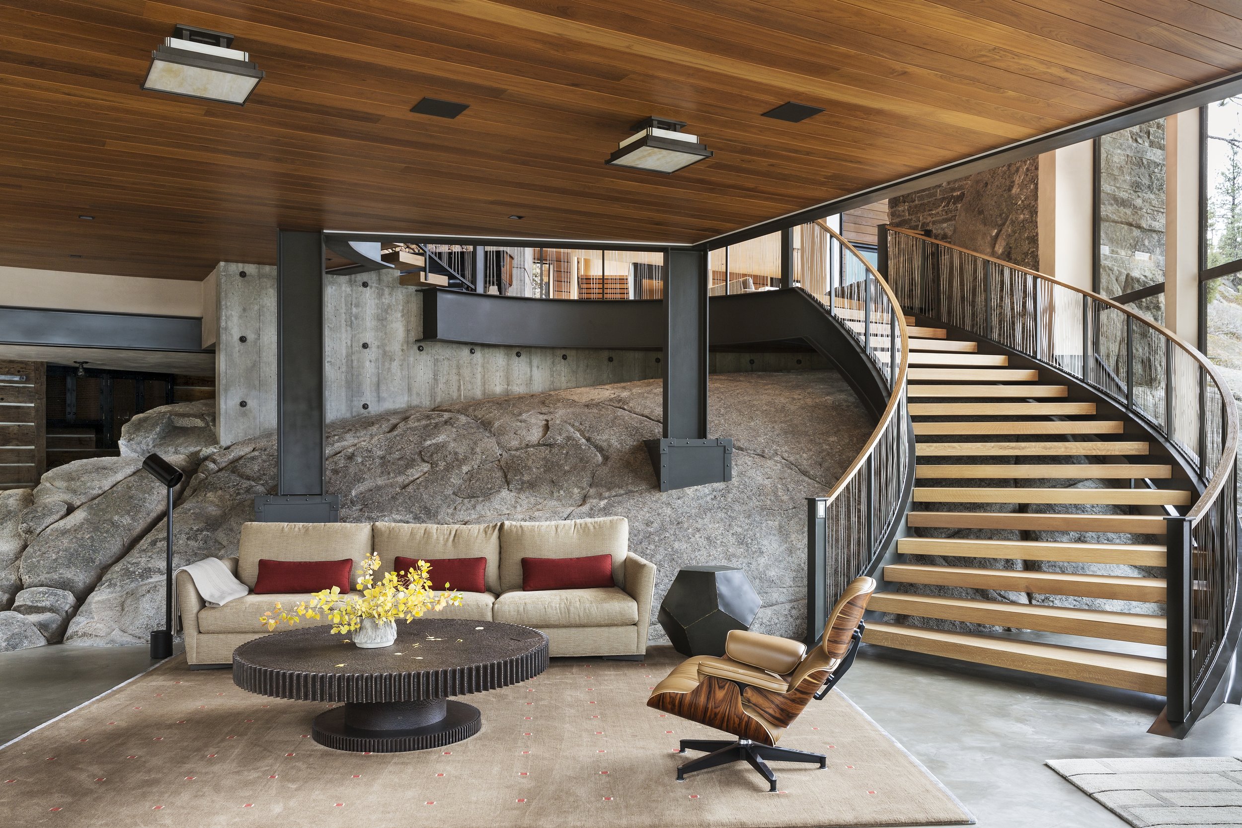 Living Room with Curved Staircase and Exposed Rock in Modern McCall, Idaho Home