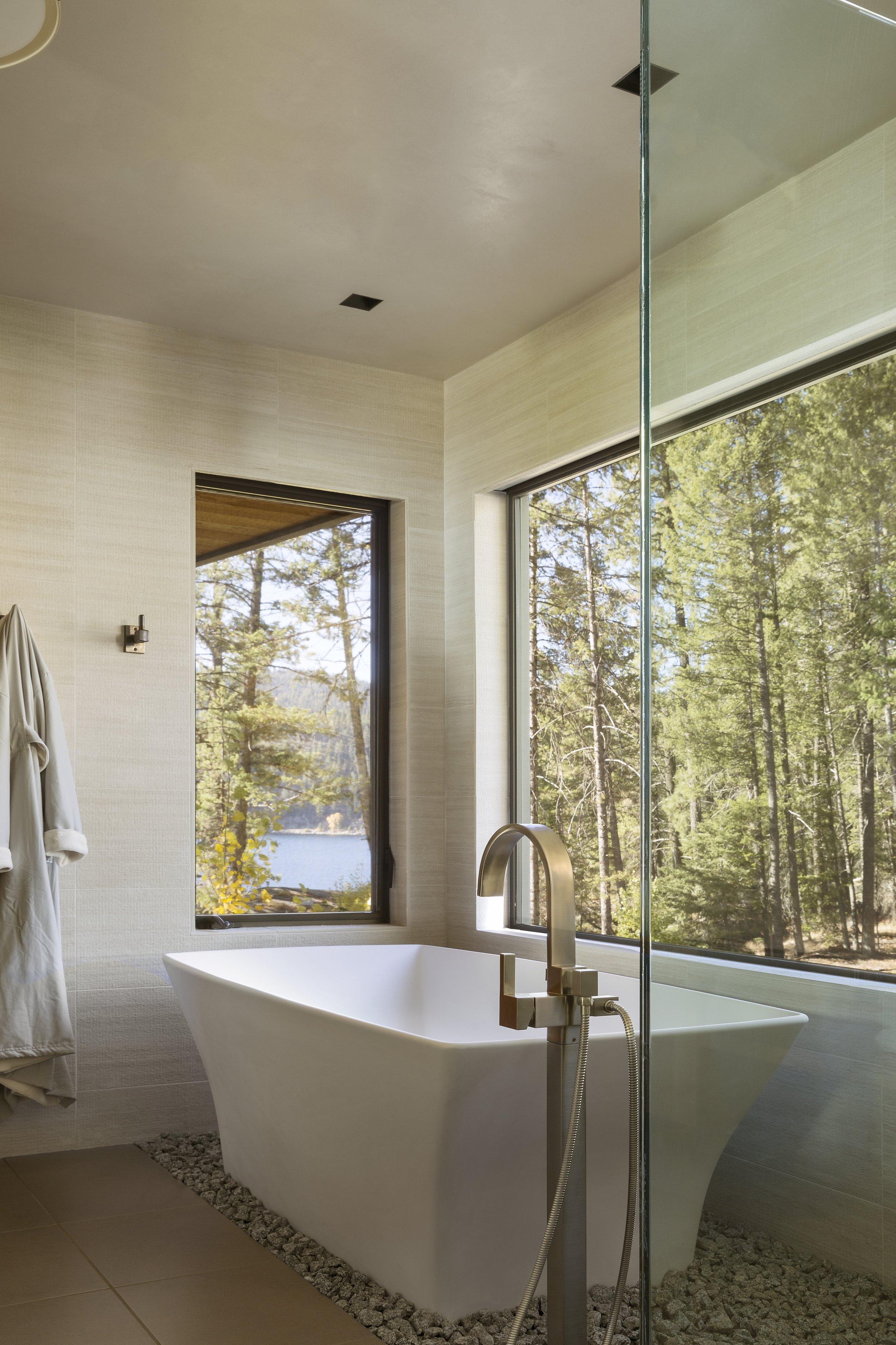 Modern Bathroom with Freestanding Tub and Forest Views in Idaho Home