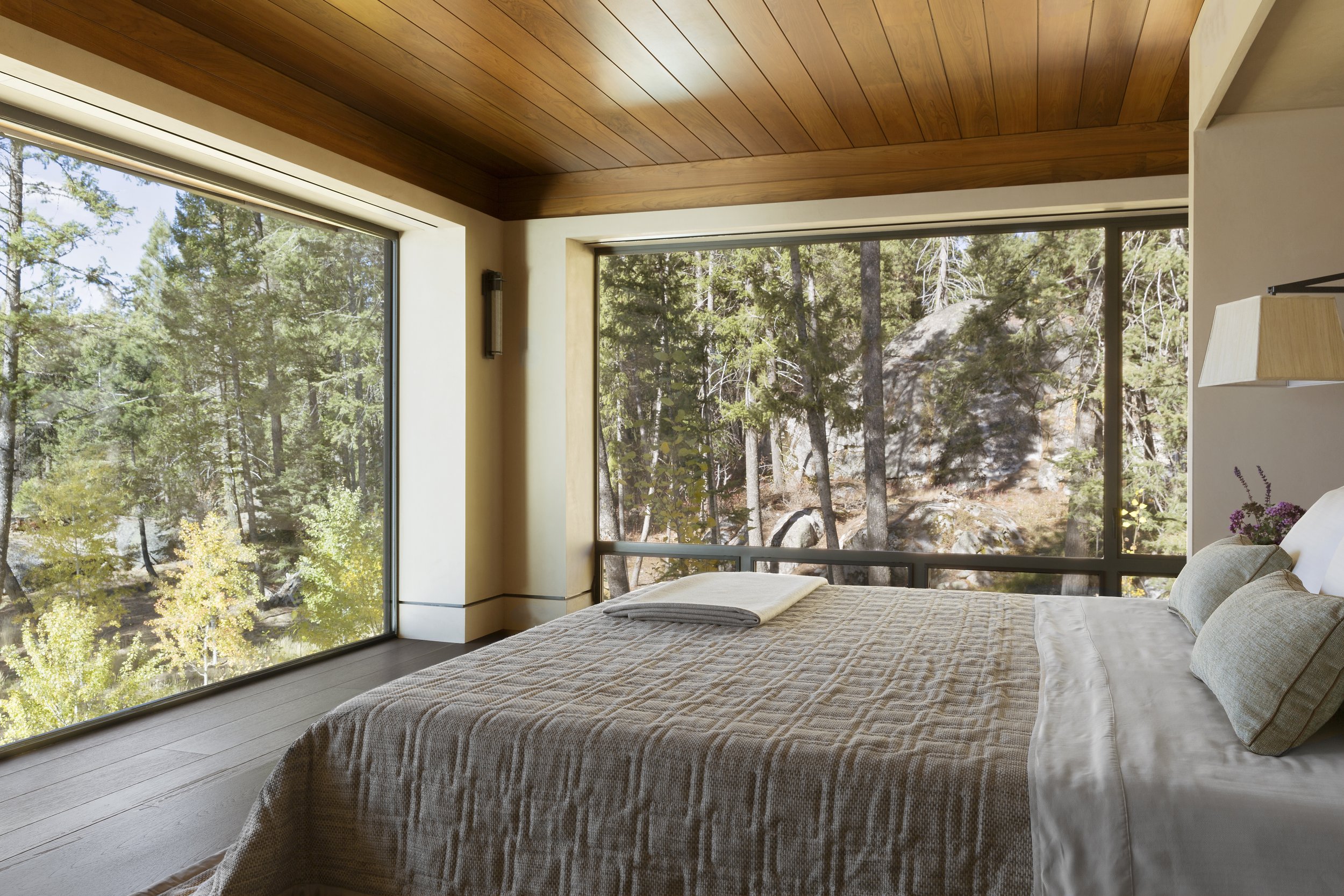 Modern Bedroom with Forest View and Wooden Ceiling in McCall Idaho Home